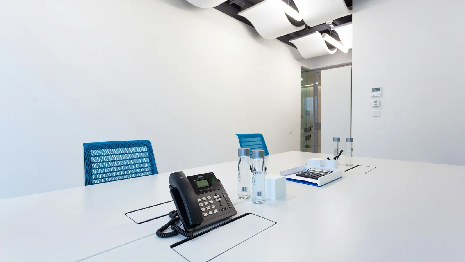 A Yealink desk phone set up on a meeting-room table.